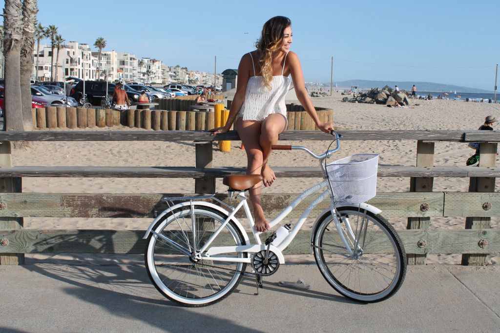 Девушка и белый пляжный велосипед
