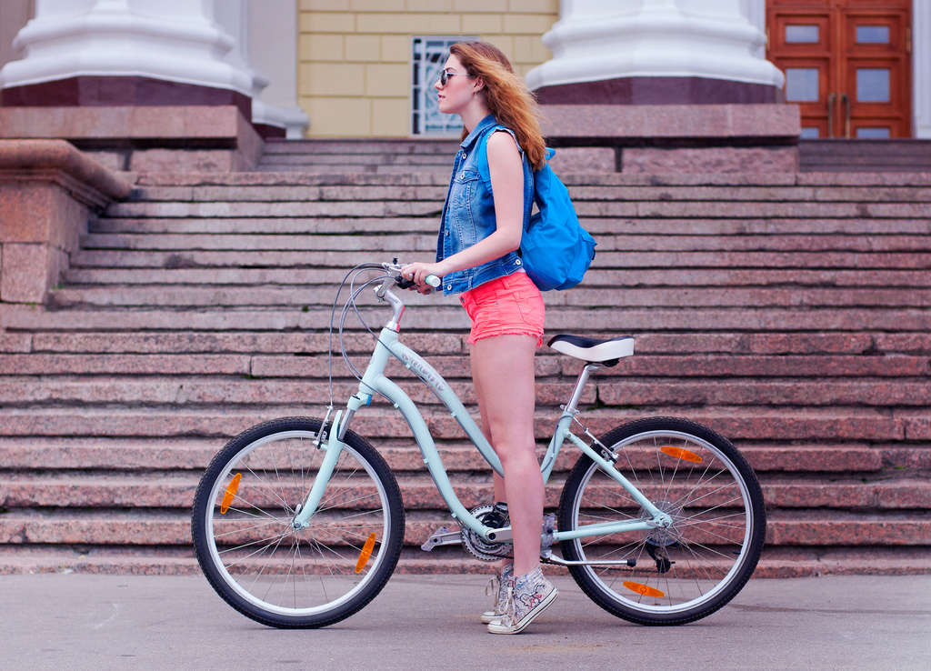 Девушка на голубом дорожном велосипеде