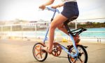 Девушка на складном голубом велосипеде