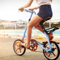 Девушка на складном голубом велосипеде