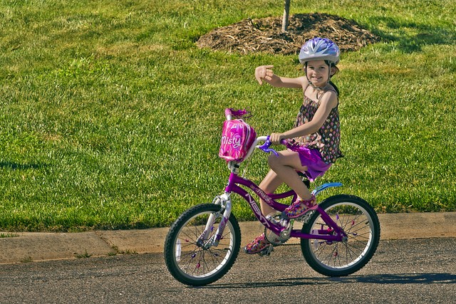 Девочка 10-и лет на фиолетовом велосипеде