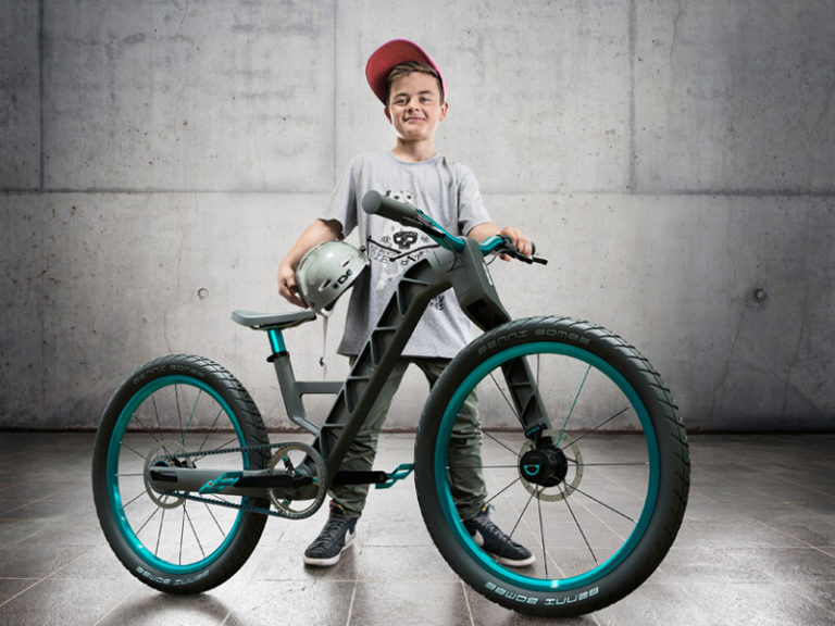 Мальчик и пластиковый серый велосипед