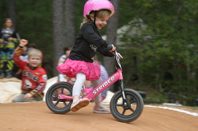 Маленькая девочка на розовом велосипеде