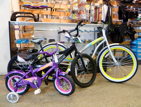 Бело-желтый велосипед, черный велосипед и черный детский велосипед