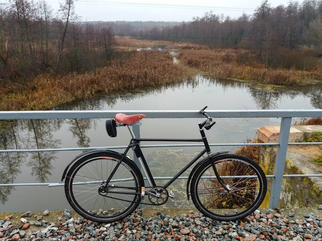 Городской велосипед у моста перед рекой