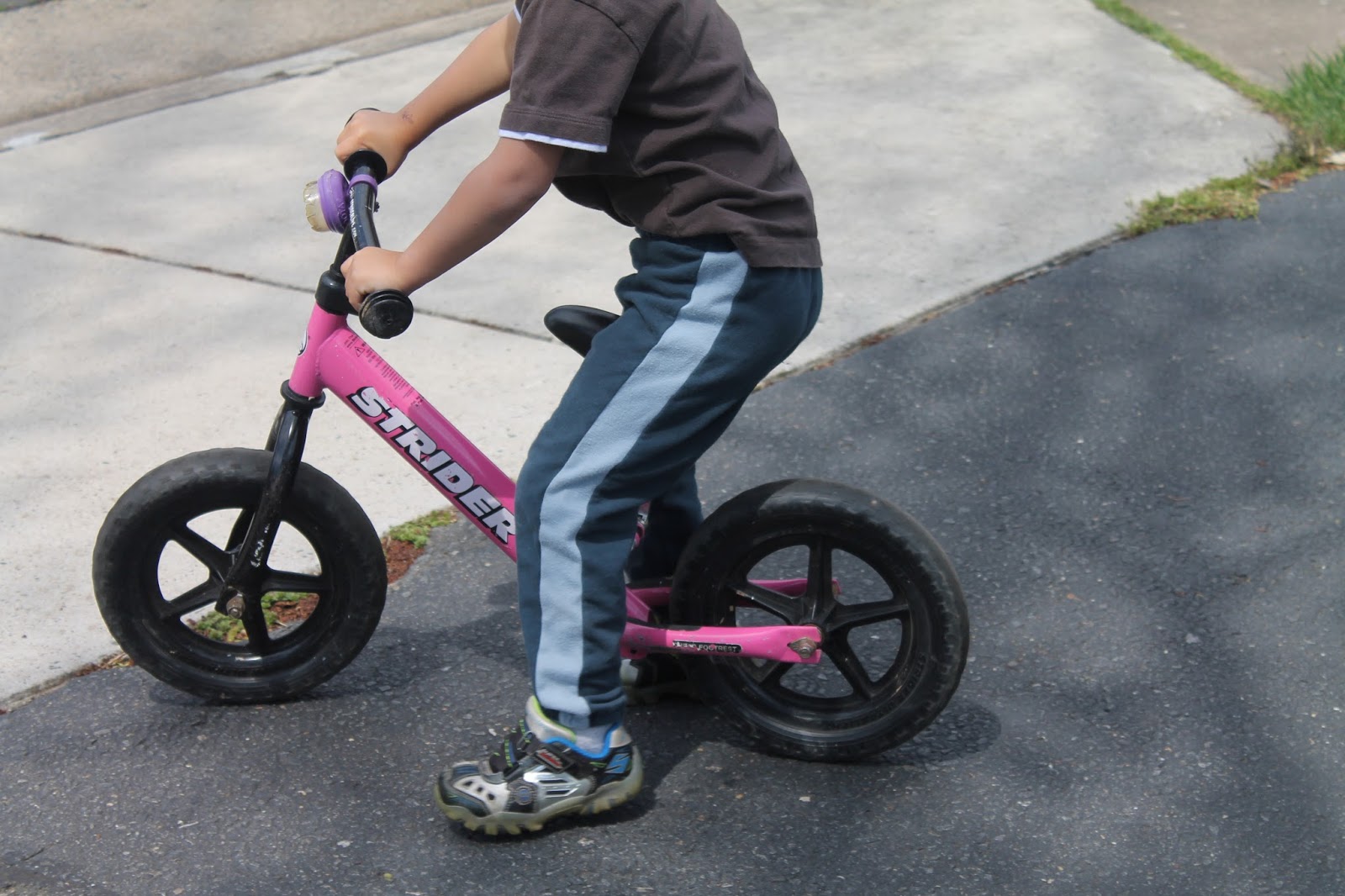 Мальчик на розовом детском велосипеде