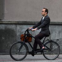 Мужчина в деловой одежде на велосипеде