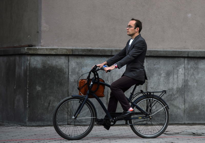 Мужчина в деловой одежде на велосипеде