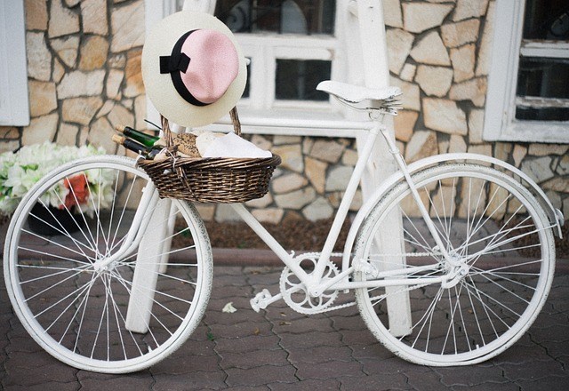 Белый велосипед с корзинкой и шляпой