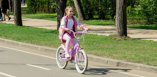Девочка в розовом на велосипеде