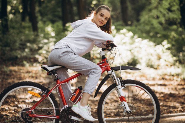 Девушка в спортивном костюме на красном велосипеде
