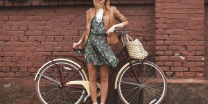 Девушка с велосипедом на фоне кирпичной стены