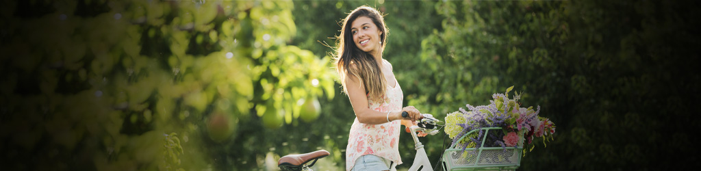 Девушка на белом велосипеде в летнем лесу