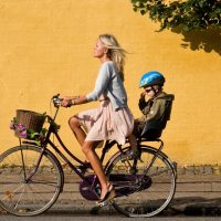 Девушка с ребенком на прогулочном велосипеде