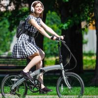 Девушка в парке на складном велосипеде