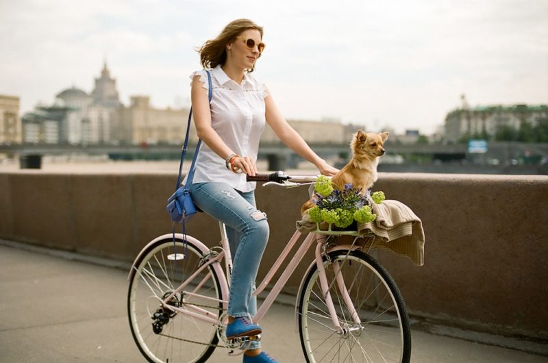 Девушка в светлой одежде на бежевом велосипеде