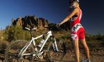 Девушка с велосипедом кросс-кантри на фоне пустыни